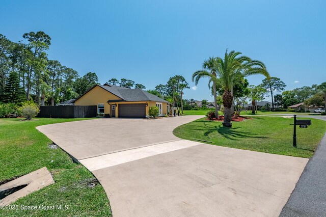 view of front of house with fence, driveway, a front lawn, and a garage
