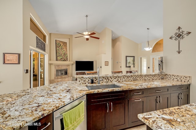 kitchen featuring a sink, high vaulted ceiling, backsplash, and light stone countertops