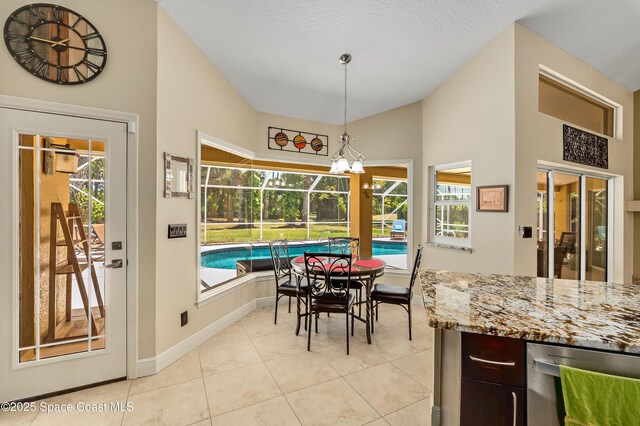 dining area featuring light tile patterned flooring, baseboards, and vaulted ceiling