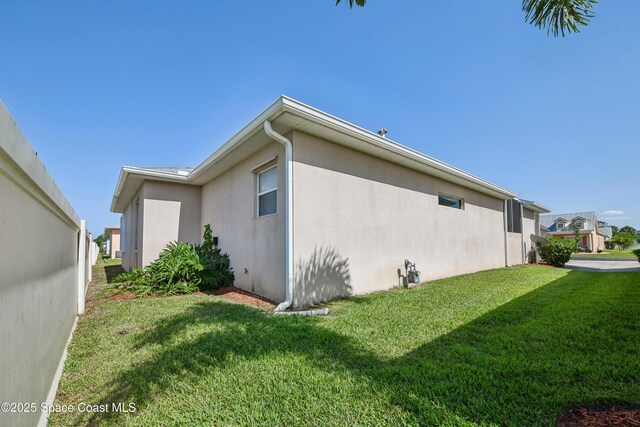 4040 Alamanda Key Dr, Melbourne, FL 32901 - view of home's exterior featuring stucco siding and a yard