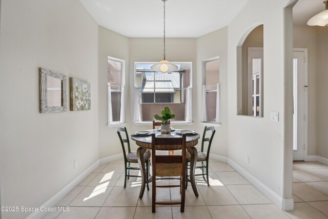 4040 Alamanda Key Dr, Melbourne, FL 32901 - dining area featuring arched walkways, light tile patterned flooring, and baseboards