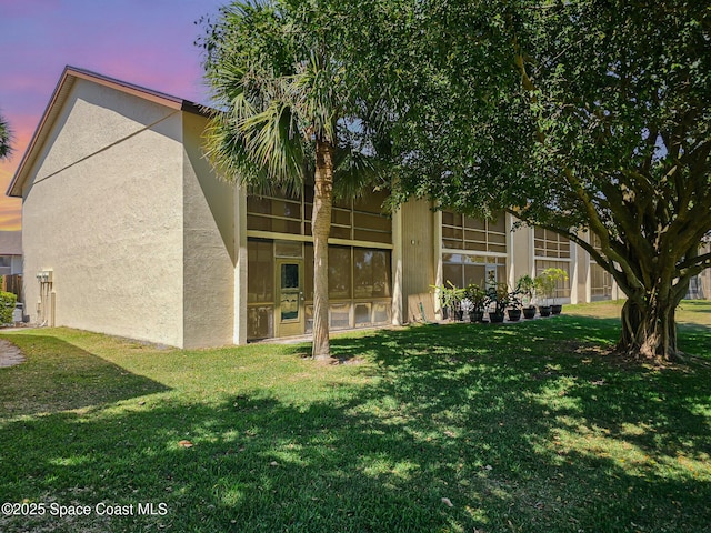2245 Golf Isle Dr Unit 424, Melbourne, FL 32935 - back of property at dusk with a yard and stucco siding