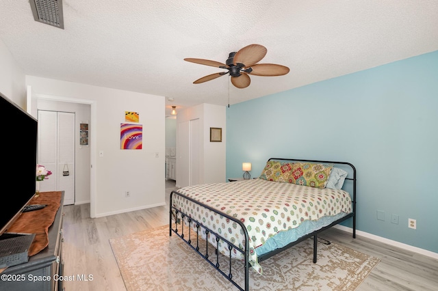 2245 Golf Isle Dr Unit 424, Melbourne, FL 32935 - bedroom featuring baseboards, a textured ceiling, visible vents, and light wood-style flooring