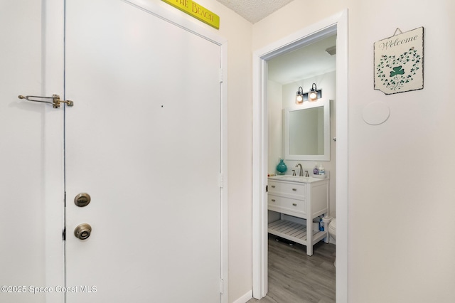 2245 Golf Isle Dr Unit 424, Melbourne, FL 32935 - hallway featuring light wood finished floors, baseboards, and a sink