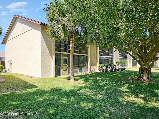 2245 Golf Isle Dr Unit 424, Melbourne, FL 32935 - rear view of property featuring stucco siding and a yard
