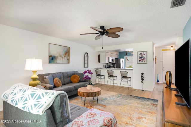 2245 Golf Isle Dr Unit 424, Melbourne, FL 32935 - living room featuring light wood-style floors, visible vents, a textured ceiling, and ceiling fan
