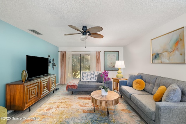 2245 Golf Isle Dr Unit 424, Melbourne, FL 32935 - living room with a textured ceiling, light wood-type flooring, visible vents, and a ceiling fan