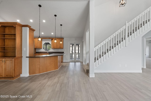 4000 Ocala St, Cocoa, FL 32926 - kitchen featuring light wood-style flooring, dark countertops, recessed lighting, brown cabinets, and hanging light fixtures