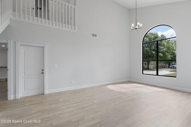 4000 Ocala St, Cocoa, FL 32926 - unfurnished room with a high ceiling, light wood-style flooring, baseboards, a notable chandelier, and visible vents