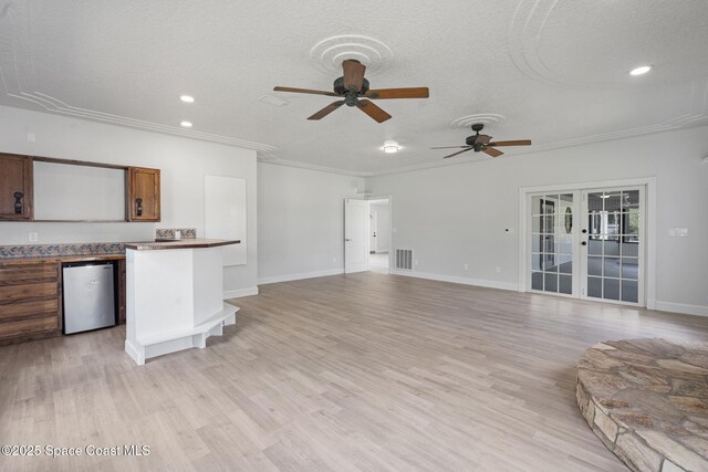 4000 Ocala St, Cocoa, FL 32926 - unfurnished living room with a textured ceiling, visible vents, a ceiling fan, and light wood finished floors