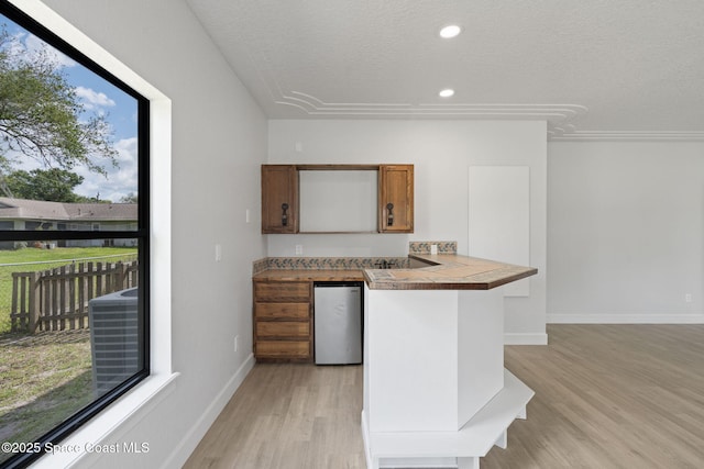 4000 Ocala St, Cocoa, FL 32926 - kitchen featuring a textured ceiling, brown cabinets, light wood-style flooring, baseboards, and recessed lighting