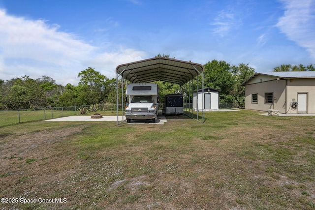 4000 Ocala St, Cocoa, FL 32926 - view of yard with a detached carport, a fire pit, fence, and a shed