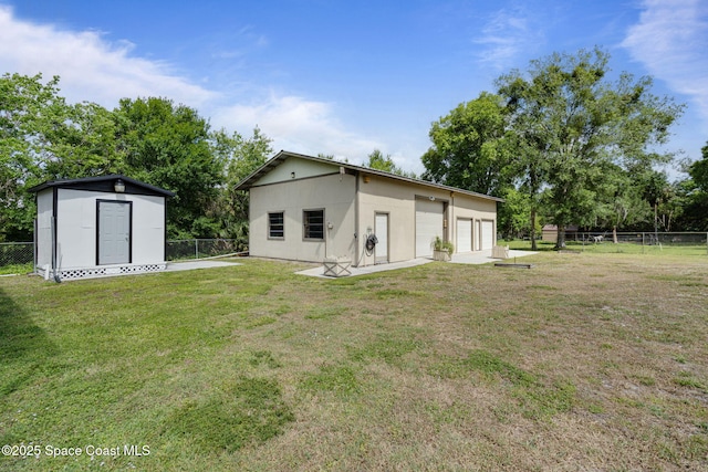 4000 Ocala St, Cocoa, FL 32926 - rear view of house with a fenced backyard, an outdoor structure, a yard, and a detached garage