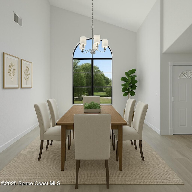 4000 Ocala St, Cocoa, FL 32926 - dining space with light wood finished floors, baseboards, visible vents, a notable chandelier, and high vaulted ceiling
