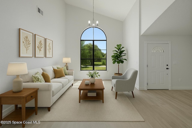 4000 Ocala St, Cocoa, FL 32926 - living room with high vaulted ceiling, wood finished floors, baseboards, a notable chandelier, and visible vents