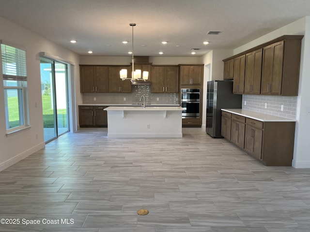 kitchen featuring a chandelier, light countertops, visible vents, appliances with stainless steel finishes, and a sink