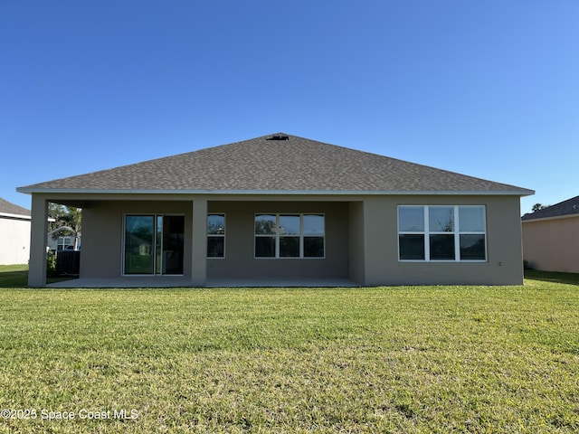 back of property featuring a patio, roof with shingles, stucco siding, and a lawn