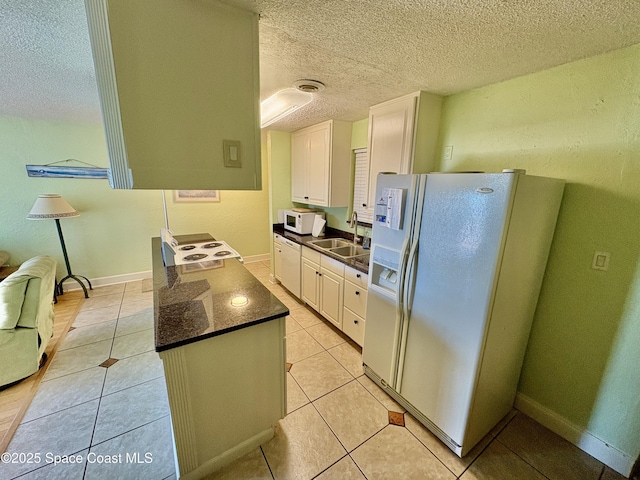 350 Taylor Ave Unit 20B1, Cape Canaveral, FL 32920 - kitchen featuring white cabinets, a sink, a textured ceiling, dark countertops, and white appliances