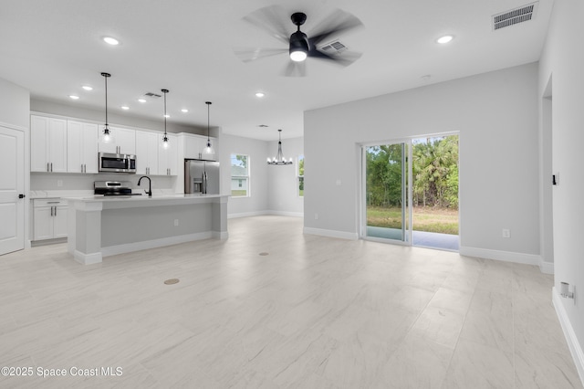 unfurnished living room with a wealth of natural light, visible vents, and recessed lighting