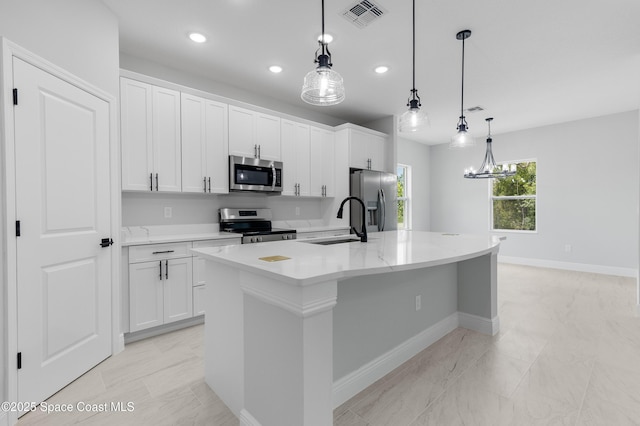 kitchen with an island with sink, a sink, white cabinets, visible vents, and appliances with stainless steel finishes