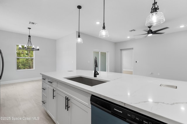 kitchen featuring dishwasher, visible vents, light stone countertops, and a sink