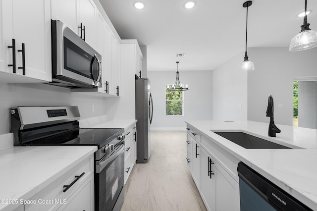 kitchen with a sink, stainless steel appliances, marble finish floor, a healthy amount of sunlight, and recessed lighting