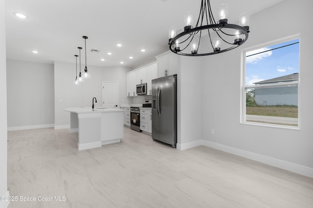 kitchen featuring a center island with sink, visible vents, baseboards, light countertops, and appliances with stainless steel finishes