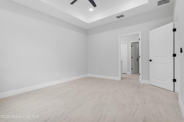 spare room with visible vents, baseboards, a ceiling fan, and a raised ceiling