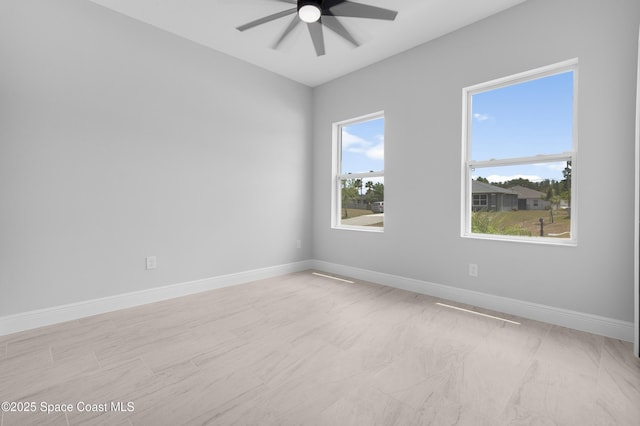 unfurnished room featuring baseboards and a ceiling fan