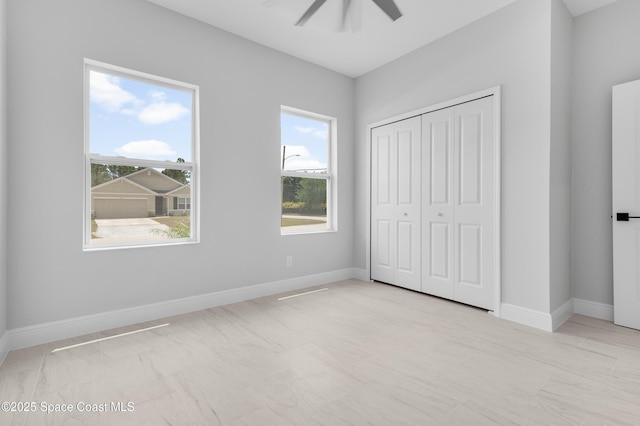 unfurnished bedroom with baseboards, a closet, and ceiling fan
