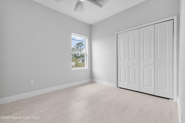 unfurnished bedroom with baseboards, a closet, and a ceiling fan