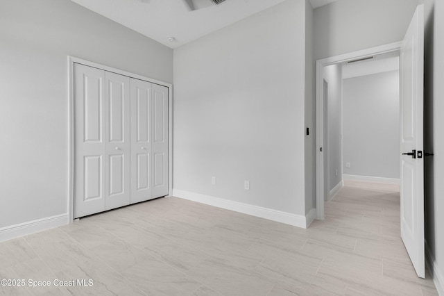 unfurnished bedroom with baseboards, a closet, and visible vents