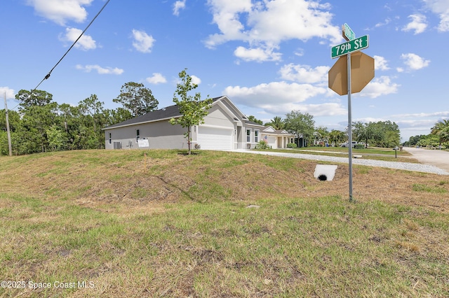 view of yard featuring concrete driveway and an attached garage