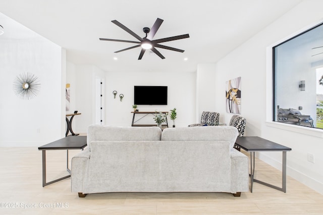 living room featuring a ceiling fan, baseboards, recessed lighting, and light wood-style floors
