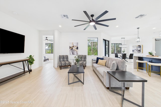 living room with recessed lighting, light wood-type flooring, visible vents, and ceiling fan