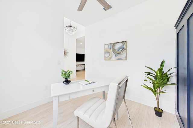 office space featuring wood finished floors, visible vents, baseboards, and ceiling fan with notable chandelier