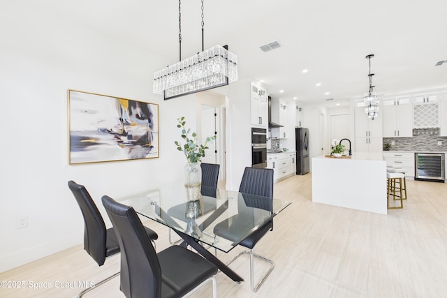 dining space with recessed lighting, wine cooler, visible vents, baseboards, and a notable chandelier