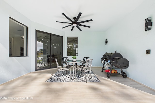 exterior space featuring baseboards, a ceiling fan, and wood finished floors