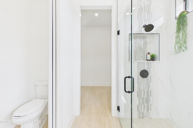 bathroom featuring baseboards, recessed lighting, a shower stall, and toilet