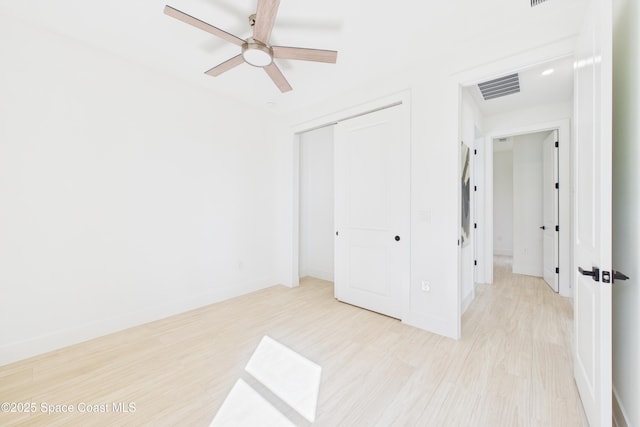 unfurnished bedroom with visible vents, a closet, baseboards, light wood-style flooring, and ceiling fan