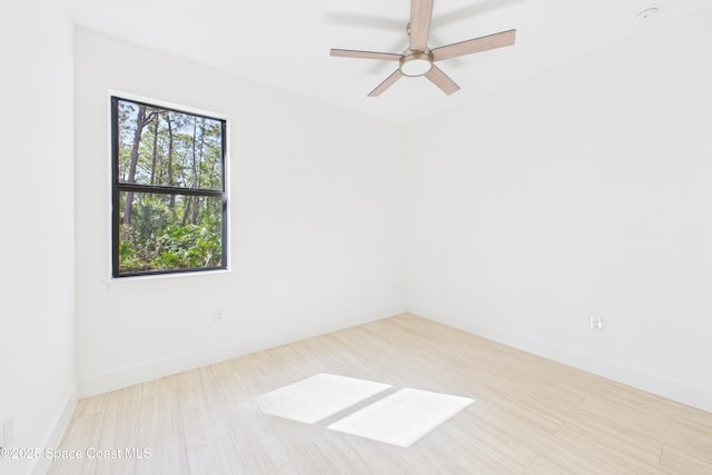 unfurnished room featuring wood finished floors, baseboards, and ceiling fan