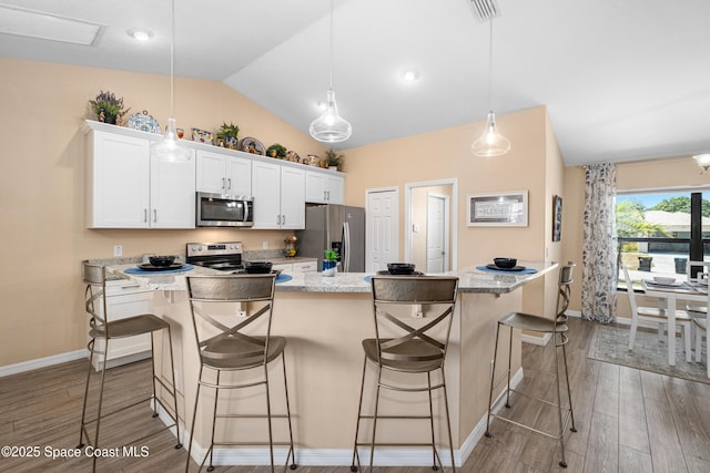 1627 Earlham Ave NW, Palm Bay, FL 32907 - kitchen featuring baseboards, appliances with stainless steel finishes, wood finished floors, and vaulted ceiling