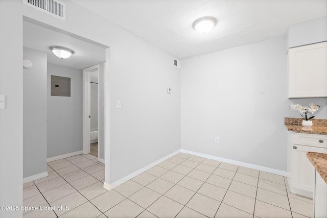 unfurnished dining area featuring electric panel, visible vents, and baseboards