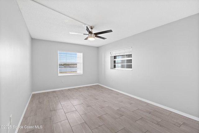 spare room with baseboards, a ceiling fan, and wood tiled floor