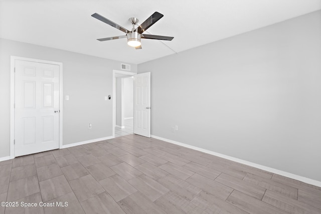 empty room featuring visible vents, baseboards, and a ceiling fan