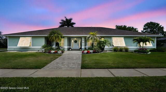 235 Northgrove Dr, Merritt Island, FL 32953 - ranch-style house with a front yard, stucco siding, and roof with shingles