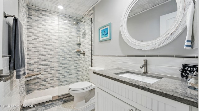 235 Northgrove Dr, Merritt Island, FL 32953 - full bath featuring tile walls, tiled shower, toilet, vanity, and wainscoting