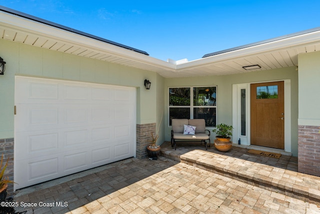 170 Maple Dr, Satellite Beach, FL 32937 - doorway to property with a garage, brick siding, and stucco siding