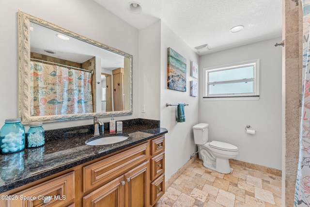 170 Maple Dr, Satellite Beach, FL 32937 - bathroom featuring toilet, a textured ceiling, vanity, stone finish flooring, and baseboards