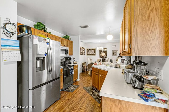 618 Americana Blvd NE, Palm Bay, FL 32907 - kitchen featuring brown cabinets, appliances with stainless steel finishes, light countertops, and light wood-style flooring